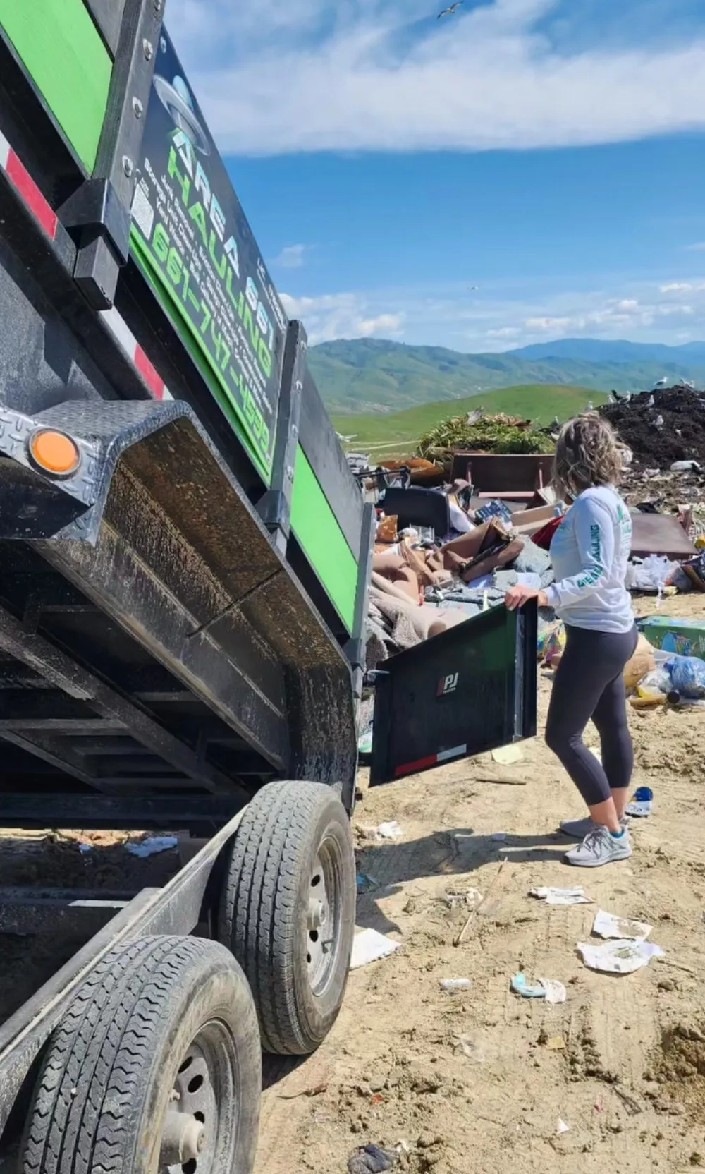 A crew loading debris into an Area 661 Hauling trailer at an open site outside Bakersfield.