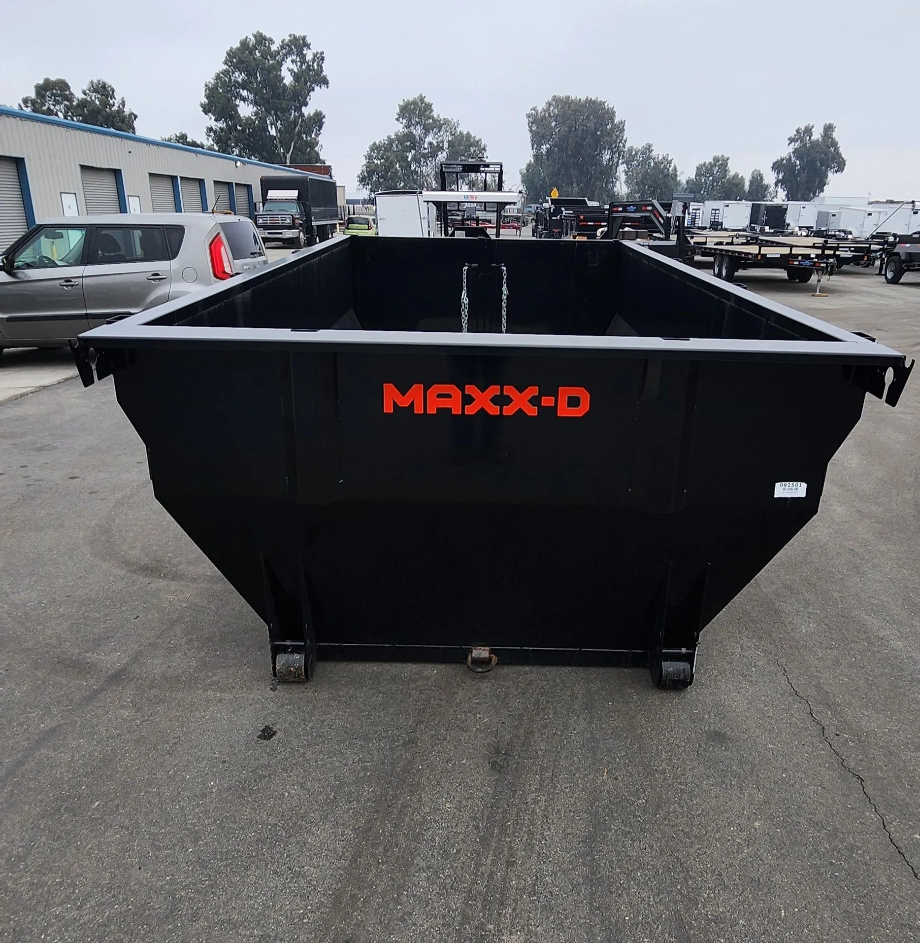 An empty black Area 661 Hauling roll-off dumpster on the pavement, ready for delivery.