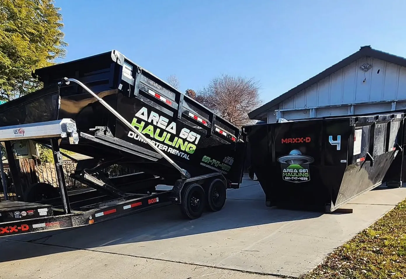 Two Area 661 Hauling dumpster trailers on a residential driveway in Bakersfield.
