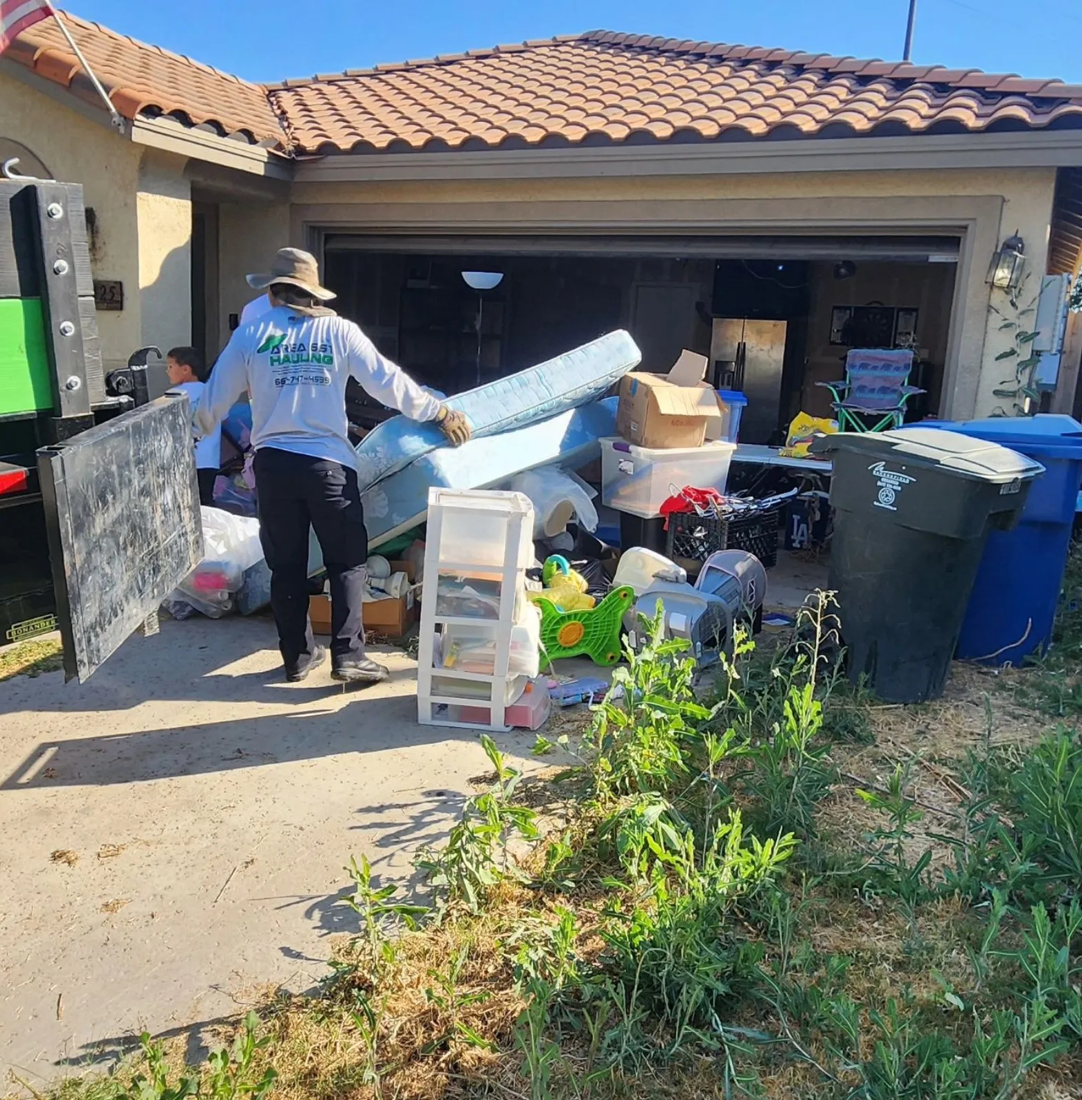 An estate cleanout in progress in Bakersfield. A man is standing in front of a garage full of items being sorted.